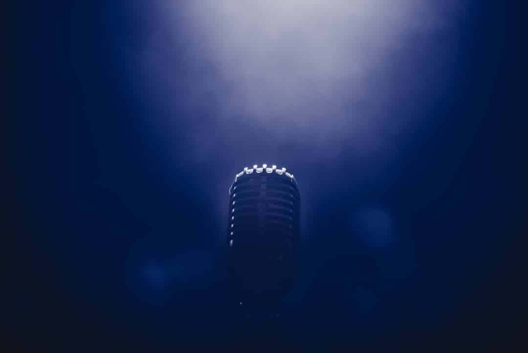 Vintage silver microphone on a dark, smoky stage.