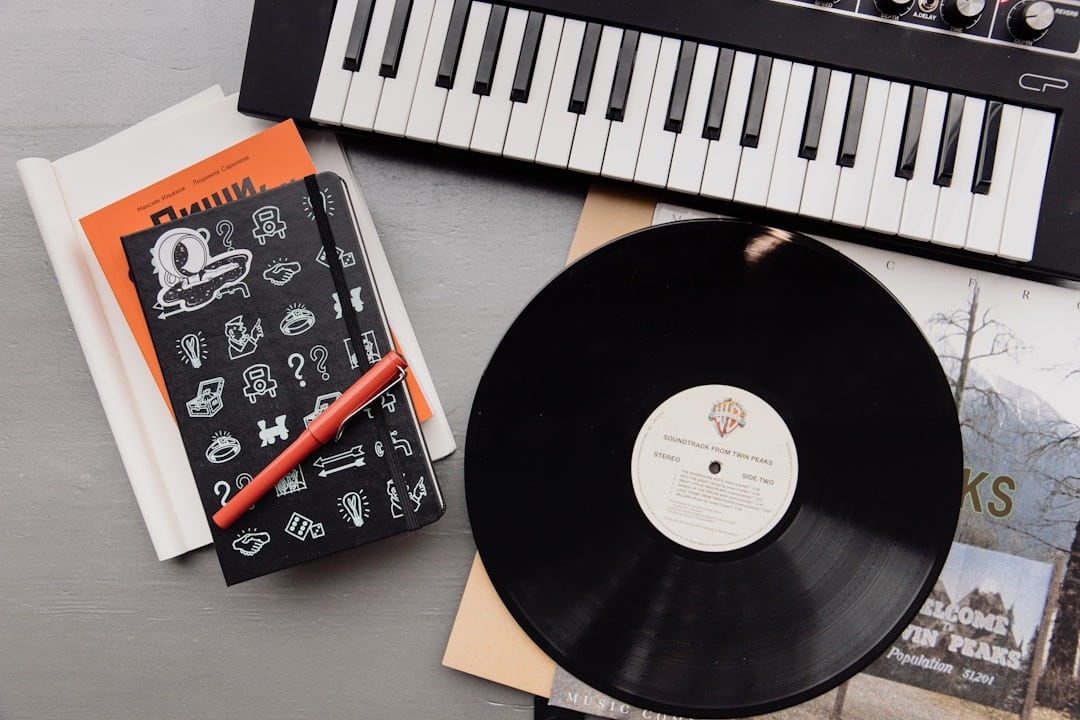 Musical equipment and stationery arranged on a grey surface.